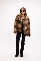 Campera de piel sintética con diseño de franjas horizontales en tonos marrones. Presenta solapas amplias, cierre frontal oculto y mangas largas de corte recto.