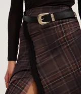 Pollera midi de tul con estampado a cuadros, diseño con abertura lateral decorada con encaje y bajo asimétrico en pico. Cuenta con cintura elástica y forro interior.