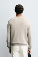 Jersey relaxed fit de algodón color beige, con cuello redondo, manga larga y efecto lavado. Los acabados son en rib.