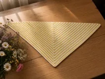 Chal pañuelo de formato triangular tejido a mano en lana merino y seda, con diseño de rayas diagonales en color amarillo y blanco.