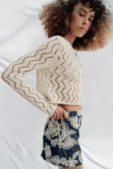 Falda pantalón corta de color azul marino con diseño bordado de flores en hilo crudo, forro interior y cierre lateral con cremallera oculta.