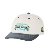 Gorra Rip Curl modelo Bells Pro 26, de diseño bicolor con cuerpo beige y visera curva en color gris oscuro con costuras blancas. Presenta bordado frontal con la leyenda "Bells Beach Australia" en tonos azules y amarillos, y detalle de campana bordada en el lateral.