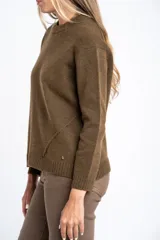 Sweater de lana color beige con diseño de motas multicolores, corte oversize, cuello redondo y puños y ruedo acanalados.