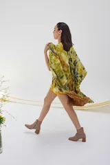 Ruana de lana merino con estampado abstracto en tonos amarillo, verde y marrón.