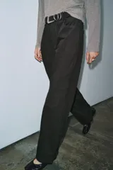 Pantalón de tiro medio con corte wide leg y diseño de rayas verticales a contraste. Cuenta con cintura con trabillas, cierre frontal con cremallera y botón, y cinco bolsillos.