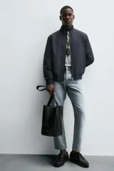 Cazadora de corte regular confeccionada en tejido técnico repelente al agua. Presenta cuello subido, manga larga con puños de rib, bolsillos laterales de vivo y cierre frontal con cremallera.