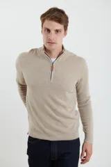 Sweater verde oliva de tejido acrílico con textura similar al cashmere, corte clásico, cuello alto con cierre metálico y tirador de cuerina ecológica.