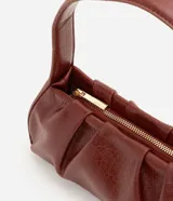 Cartera baguette de marca Satinato confeccionada en poliuretano con textura crocco en color marrón. Cuenta con diseño estructurado, cierre de cremallera y asa fija de hombro.