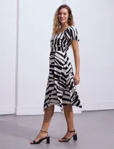 Vestido midi de rayón y lino con estampado geométrico en blanco y negro, escote cuadrado, mangas cortas con elástico y cintura elastizada.