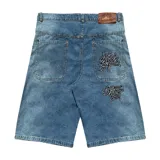 Bermuda de jean de corte baggy, lavado celeste con efecto desgastado. Presenta bordados grandes en los bolsillos traseros con caracteres chinos en negro y blanco. Tiene un parche de cuero marrón en la cintura trasera.