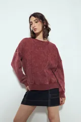 Buzo de calce relajado color bordó con efecto lavado y costuras verticales a la vista.
