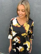 Blusa de satén con escote en V y mangas tres cuartos acampanadas, con estampado abstracto en tonos negro, caramelo, verde lima y blanco.