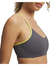 Top deportivo Under Armour Halo Bonded color gris con detalles en amarillo flúor. Diseño de espalda deportiva con tirantes finos y banda elástica bajo el busto. Ideal para actividades de bajo impacto.
