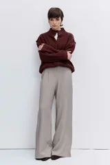 Cardigan de punto acanalado en color bordó, con cuello polo y cierre frontal de botones. Presenta un diseño de hombros caídos y mangas largas con puños ajustados.