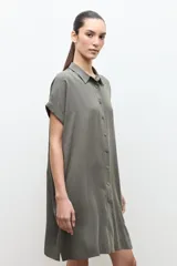 Túnica de lyocell color verde oliva, de corte holgado, con cuello camisero, cierre frontal con botones y mangas cortas con vuelta.