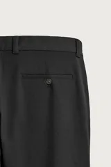 Pantalón chino negro slim fit de corte recto, con bolsillos frontales, trabillas para cinturón y cierre frontal con cremallera y botón.