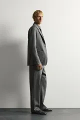 Blazer de corte relaxed fit de Zara, confeccionado en 100% lana color gris. Cuenta con cuello de solapas de muesca, manga larga, bolsillos de parche en la cadera, bolsillo de vivo en el pecho y cierre frontal con un botón.
