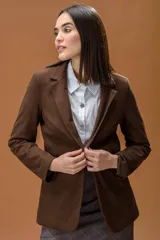 Blazer de corte clásico y estructurado en color marrón con textura de espiga. Presenta solapas tradicionales, cierre frontal y mangas largas.