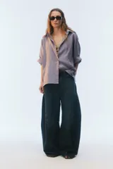 Camisa oversize blanca de lino, con corte cuadrado, mangas raglán cortas con puños anchos, aberturas laterales y cierre frontal de botones.