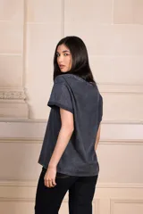 Remera negra con efecto gastado, escote en "v" y estampado frontal de cerezas con moño rosa y texto "Cherry Bomb" en verde.