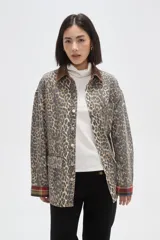 Campera de jean con estampado animal print, cuello de pana en color marrón, cierre frontal con botones metálicos, bolsillos frontales con solapa y puños con detalle de tela escocesa en tonos rojos y azules.