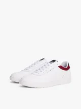 Zapatillas de estilo retro baloncesto Tommy Hilfiger, de corte bajo, confeccionadas en piel y poliuretano. Presentan un diseño en color blanco con paneles en contraste en color granate y azul marino en el talón. Cuentan con suela gruesa de goma, detalle de ventilación en la parte superior y logo de la marca en el lateral y la lengüeta.