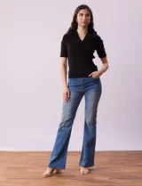 Buzo azul de tejido acanalado, con cuello solapa y escote en V en tejido calado.