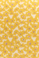 Pañuelo cuadrado de tela ligera con estampado floral en tonos amarillo y blanco con detalles en violeta.