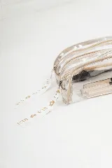 Necessaire transparente de PVC con cierre y bordes en color beige, ideal para guardar artículos pequeños de maquillaje o cuidado personal.