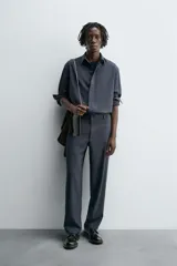 Pantalón de corte relaxed fit, con cintura ajustable, bolsillos delanteros y bolsillo trasero de plastrón. Presenta cierre frontal con cremallera y botón.