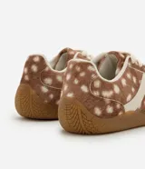 Championes Satinato con diseño de animal print tipo ciervo, confeccionados en cuero sintético con textura suave. Presentan recortes laterales en tono crema, cierre con cordones y suela de goma antideslizante.