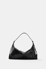 Bolso de hombro de diseño hobo en color negro, con acabado efecto cuero desgastado. Cuenta con asa ajustable, cierre principal mediante cremallera y detalles metálicos en los laterales.