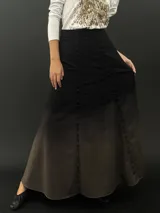 Falda larga de lana color negro con teñido degradado en tonos grises. Corte a la cintura con bolsillos laterales y cierre invisible.