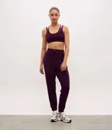 Pantalón tipo jogger de mujer, confeccionado en tejido modal con mezcla de poliéster y elastano. Presenta cintura elástica con lazo de ajuste, bolsillos laterales y puños elásticos en el ruedo.