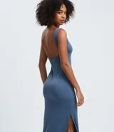 Vestido largo tipo midi de corte ajustado, confeccionado en poliamida con elastano. Presenta escote cuadrado, breteles anchos y una abertura lateral en el ruedo.