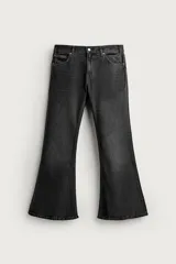 Jeans flare fit de denim de algodón color negro con efecto gastado, tiro medio y diseño ajustado en la parte superior con apertura en campana desde la rodilla. Cuenta con cinco bolsillos, bajo con acabado irregular y cierre frontal con cremallera y botón.