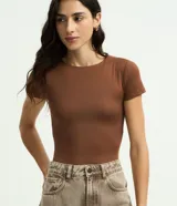 Body de poliamida color topo, con cuello redondo, mangas cortas y cierre en la entrepierna. Diseño ajustado al cuerpo.