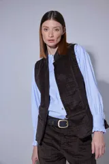 Chaleco de pana color bordó, con cierre frontal de botones y bolsillos laterales.