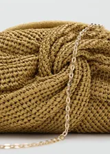 Bolso tipo clutch de fibra natural en color tostado, con diseño trenzado y nudo frontal central, cierre de aro a presión y forro interior.