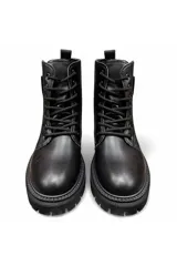 Bota de estilo militar en color tostado, con cordones frontales y suela track gruesa. Presenta un cierre lateral decorativo con tirador negro y letras estampadas.