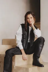 Top negro de cuero de oveja y gamuza de cabra, con cuello camisero, apliques tribales y cartera escondida con botones.