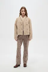 Tapado de textura tipo corderito en color marrón, con cuello solapa y cierre frontal de botones.