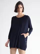 Sweater largo azul marino de tejido de punto, con cuello redondo, mangas 3/4, bolsillo lateral y botones decorativos en el ruedo.