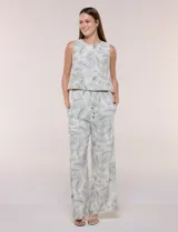 Pantalón palazzo de tiro alto y corte amplio, marca Allie Rose, con estampado botánico de hojas verdes sobre fondo blanco. Presenta cintura elastizada fruncida con cordón de ajuste y bolsillos laterales.