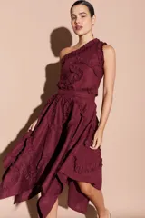 Falda midi asimétrica color bordó, con volados decorativos en espiral y cierre lateral.