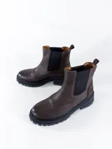 Botas Chelsea de cuero color marrón chocolate, con elásticos laterales negros y suela track negra.