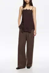 Pantalón de corte recto y tiro alto, confeccionado en una mezcla de lyocell y viscosa, con acabado mate y diseño de pierna ancha.