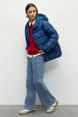 Campera puffer color ladrillo de nylon con capucha, dos bolsillos laterales con cierre y un bolsillo adicional con solapa en la manga izquierda.