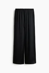 Pantalón holgado de satén negro, con piernas amplias, cintura elástica con cordón ajustable y bolsillos laterales.