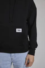 Buzo hoodie azul marino de algodón con corte holgado, capucha con cordones ajustables, bolsillo tipo canguro y etiqueta con logo en el frente.